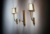 Jean PASCAUD (1903-1996) Set consisting of a double sconce and a pair of single sconces in patinated gilt bronze.
