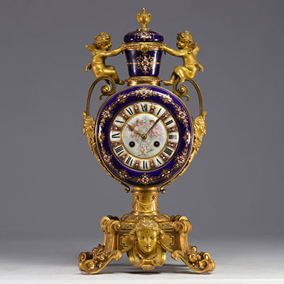 Rare pendule en porcelaine de Sèvres et bronze doré à décor d'angelots.