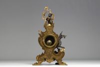 A 19th century ormolu and patinated clock decorated with a Putto and a winged dragon.