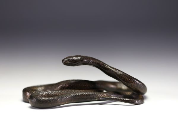 Patinated metal sculpture depicting a snake.