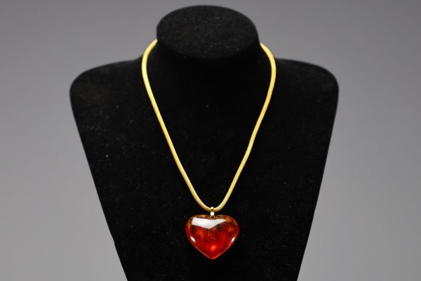 Yves SAINT LAURENT - Collier en coeur, imitation ambre et métal doré, signé.