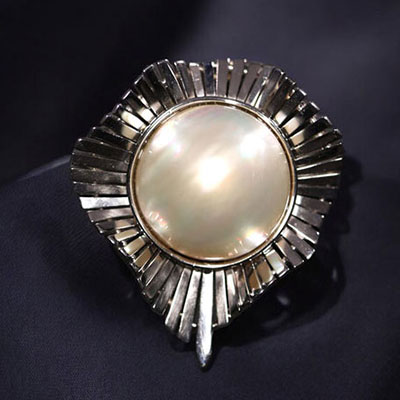 Grande perle montée sur un broche en or blanc pouvant également être portée en pendentif, poids total de 23gr.