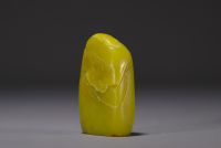 China - Yellow stone seal carved with a figure in a landscape and engraved with a poem.