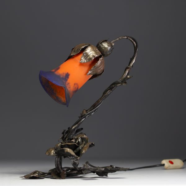 Lampe de table, pied en fer forgé à décor floral, bobèche en pâte de verre orange et bleue, vers 1900-20.