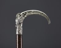 A silver-plated bronze cane with a handle carved with an owl with open wings.