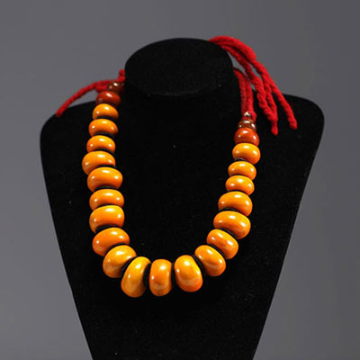 Chine - Collier en ambre compose de vingt-trois grosses perles séparées par des pastilles de feutre.