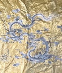 China - Gold silk tapestry decorated with blue dragons.