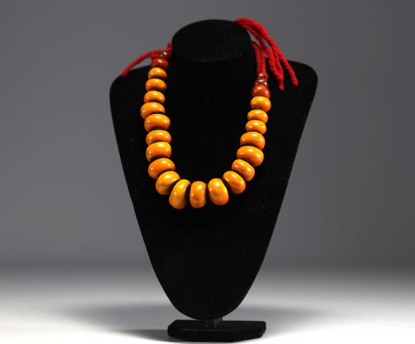 China - Amber necklace composed of twenty-three large pearls separated by felt lozenges.