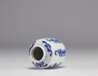 A small white and blue vase decorated with flowers and women in traditional dress from the Kangxi period (1661-1722) with a mark under the piece