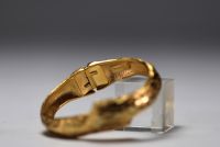 Yves SAINT LAURENT - Gilt metal bracelet, signed.