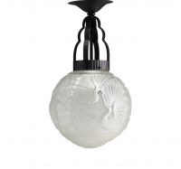 Art Deco pendant light in stylized glass with peacock decoration and hammered metal frame.