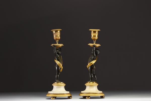 Paire de bougeoirs en bronze à deux patine, doré et ciselé figurant un couple de chérubins, époque Louis XVI.