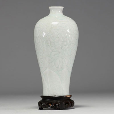 China - An 18th century celadon porcelain vase decorated with flowers in relief.