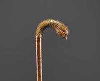 Carved wooden cane with bird's head motif, glass eyes.