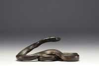 Patinated metal sculpture depicting a snake.