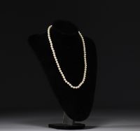 Christian DIOR - Collier de perles, fermoir doré, signé.