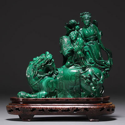 Chine - Sculpture en malachite représentant un chien de Fô et personnages, sur socle en bois.