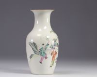 A Famille Rose porcelain vase decorated with figures and a tree on a white background