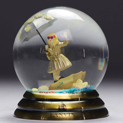 LAVIN PARIS glass snow globe depicting a woman wearing a gold dress with a sequined umbrella