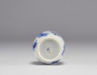 Petit vase en blanc et bleu à décor de fleurs et de femmes en habits traditionnels de l'époque Kangxi (1661-1722), marque sous la pièce.