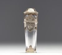 A rare solid silver and crystal perfume bottle decorated with musical instruments, foliage and flowers, the stopper representing a greyhound in vermeil, 19th century.