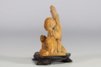 China - Hard stone sculpture of a figure with a lion on a wooden base.