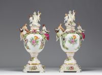 Paire de vases couverts en porcelaine à riche décor polychrome de personnages et de fleurs dans le goût de Capodimonte.