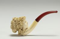 Pipe en écume sculptée d'une tête de femme, dans son fourreau, XIX-XXème.