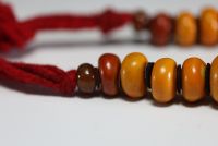 Chine - Collier en ambre compose de vingt-trois grosses perles séparées par des pastilles de feutre.