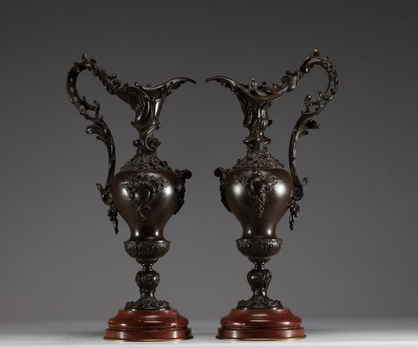 Paire de verseuses en bronze de style Louis XV sur socles en marbre rouge.