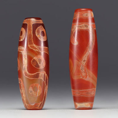 Tibet - Pair of Dzi amulets, one with ‘9 eyes’ in red agate, fine specimens from the 19th century.