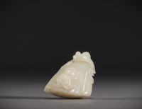 Chine - Pendentif en Jade blanc sculpté en forme de fruit surmonté d'un jeune enfant.
