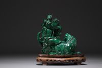 Chine - Sculpture en malachite représentant un chien de Fô et personnages, sur socle en bois.