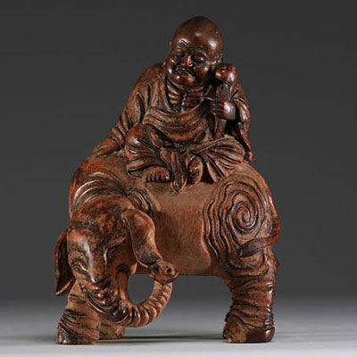 China - Buddha seated on an elephant, sculpture in patinated bamboo.