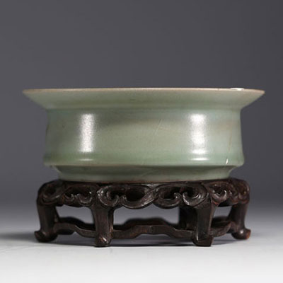 Chine - Coupe en porcelaine céladon sur socle en bois sculpté, dynastie Song.