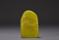 China - Yellow stone seal carved with a figure in a landscape and engraved with a poem.