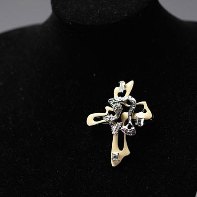 Christian LACROIX - Cross brooch, rhinestones and beige enamel on silver-plated metal, signed.