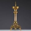 A large ormolu and chased bronze candlestick with a chalice decorated with a crown and leaves.