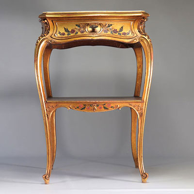 Gilded table decorated with flowers resting on a marble shelf