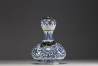 China - A white-blue porcelain vase with floral decoration surmounted by two bronze chimeras.