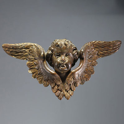 An 18th century carved wooden cherub with open wings.