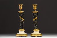 Paire de bougeoirs en bronze à deux patine, doré et ciselé figurant un couple de chérubins, époque Louis XVI.