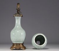 China - A celadon porcelain oil lamp and shaft decorated with flowers and bamboos, 18th-19th century.