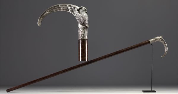 A silver-plated bronze cane with a handle carved with an owl with open wings.