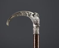 A silver-plated bronze cane with a handle carved with an owl with open wings.