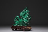 Chine - Sculpture en malachite représentant un chien de Fô et personnages, sur socle en bois.