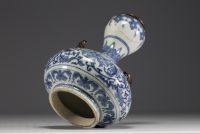 China - A white-blue porcelain vase with floral decoration surmounted by two bronze chimeras.