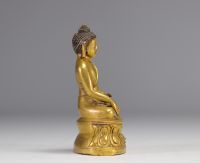 Sculpture of a seated Buddha on a gilded bronze base