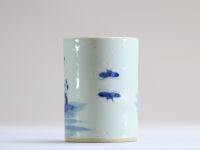 China - A white and blue porcelain brush pot decorated with dignitaries.