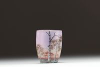 DAUM Nancy - Vase miniature en verre multicouche dégagé à l'acide et émaillé à décor de paysage lacustre et de bouleaux, signé sous la base.